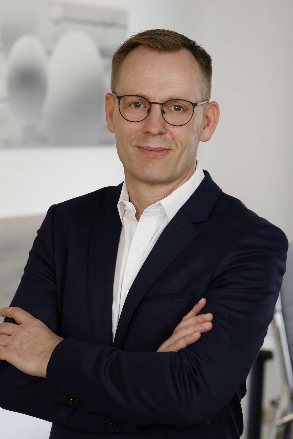 Hendrik Thomalla von Thomalla & Fischer Immobilien im Porträt, mit verschränkten Armen im Büro