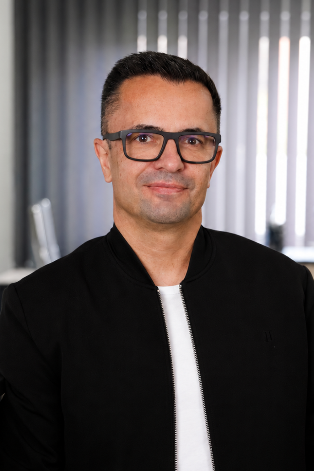 Mario Fischer von Thomalla & Fischer Immobilien im Porträt, mit Brille und dunklem Sakko
